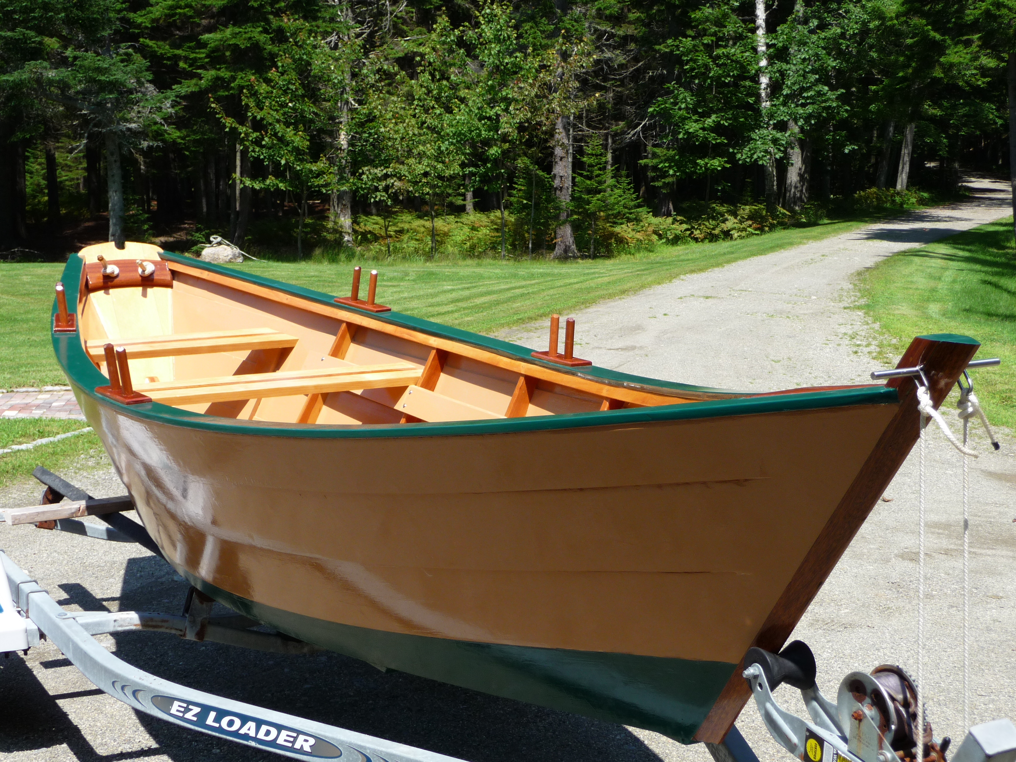 Beautifully finished Grand Banks dory on trailer, green gunwales and golden hull